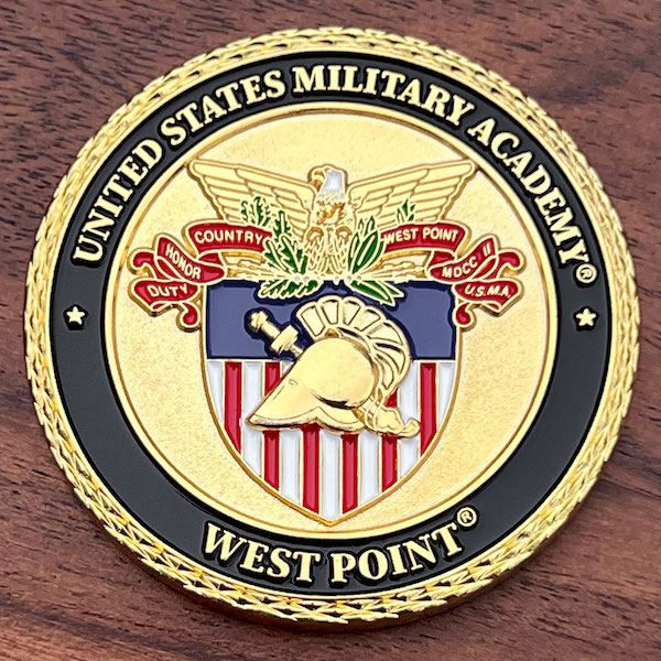 Round polished gold challenge coins belonging to West Point Military Academy.