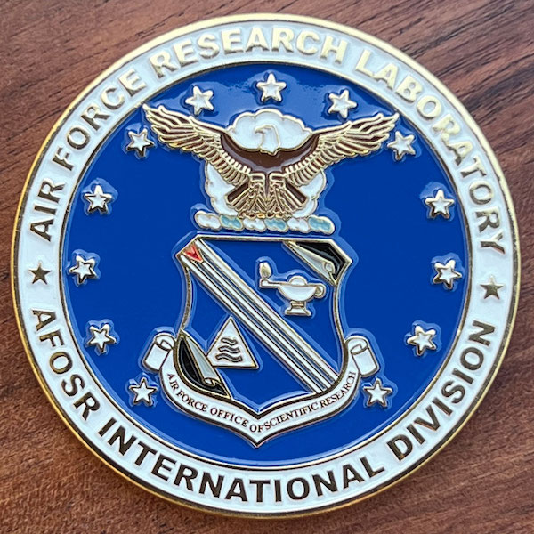 Round polished gold challenge coin belonging to Air Force Research Laboratory AFOSR International Division