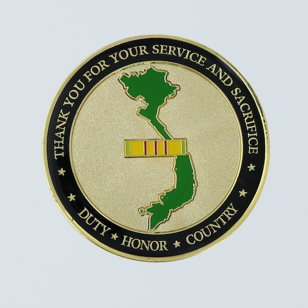 Reverse side of a round gold challenge coin honoring Vietnam veterans. 