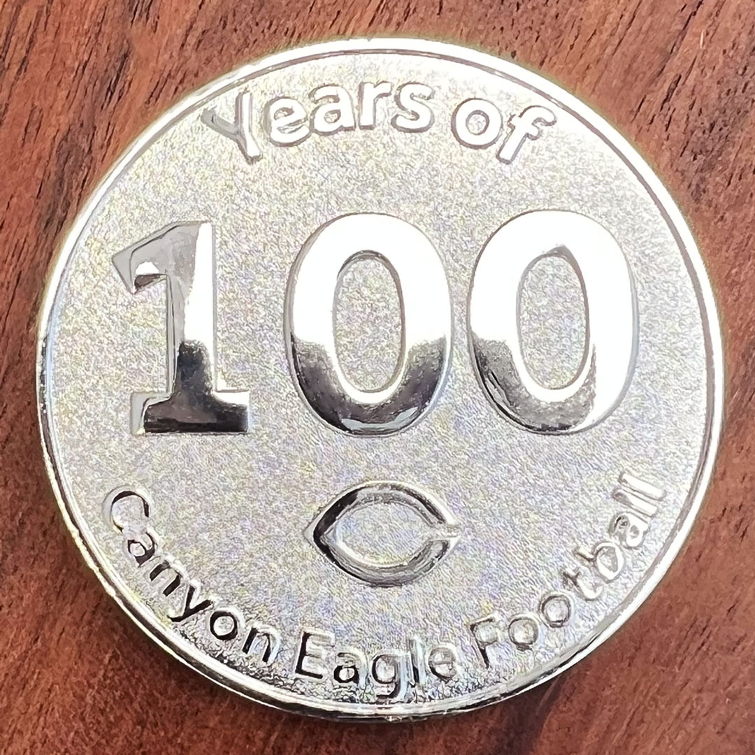 Polished silver coin created for Canyon Texas High School Canyon Eagles football team. "100" at center.