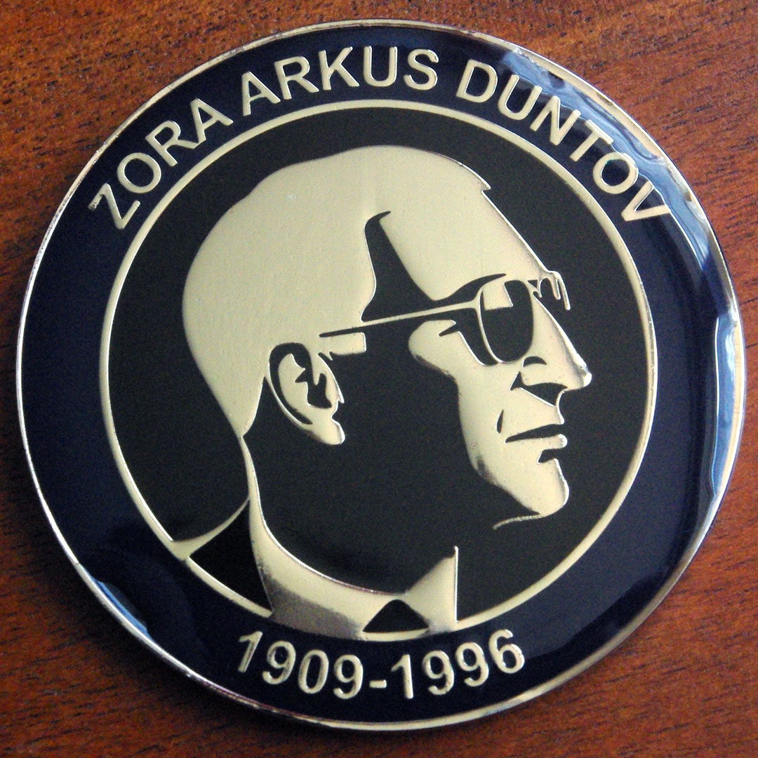 Round coin featuring silhouette of Zora Arkus-Duntov