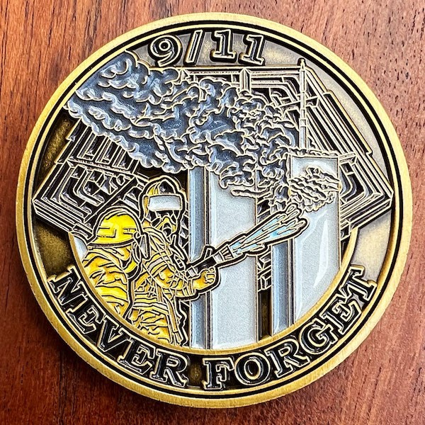 round challenge coin with 9/11 firefighter image and "Never Forget"