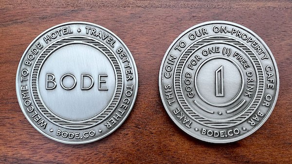 Front and reverse of round challenge coin belonging to Bode Hotel