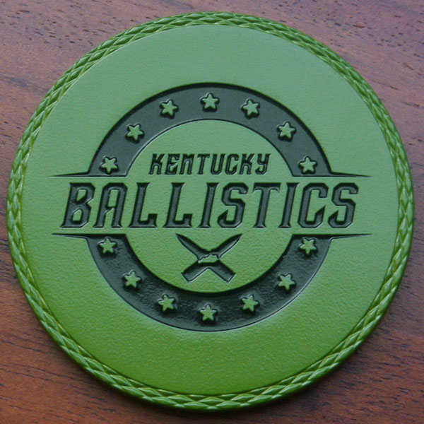 Round green dyed metal challenge coin for Kentucky Ballistics. 