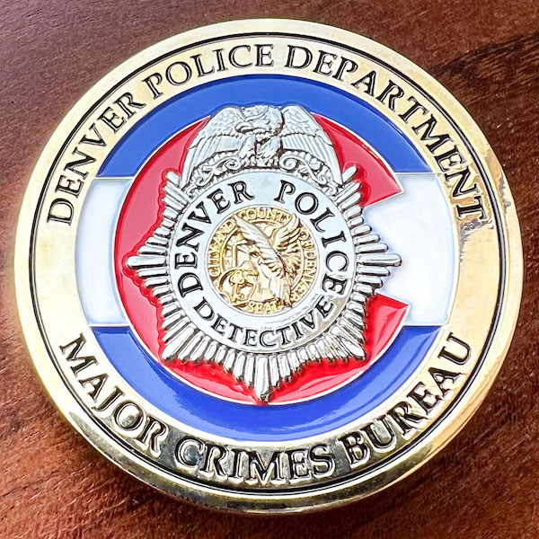 Round polished gold challenge coin belonging to the Denver Police Department. 