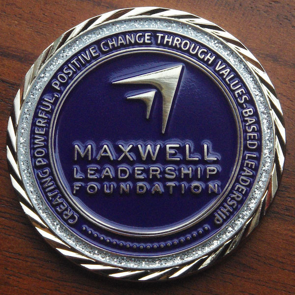 Round polished silver challenge coin belonging to the Maxwell Leadership Foundation. 