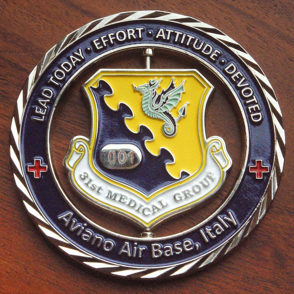 Round silver challenge coin representing the 31st Medical Group stationed at Aviano Air Base, Italy. 