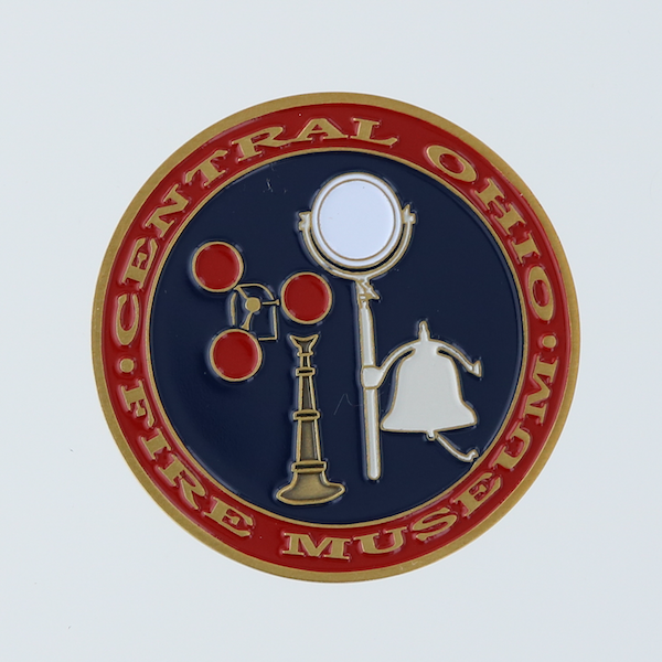 Round challenge coin with fire signal devices in center. Signals red, gold, white on blue background. Red border wih Central Ohio Fire Museum letters in gold.