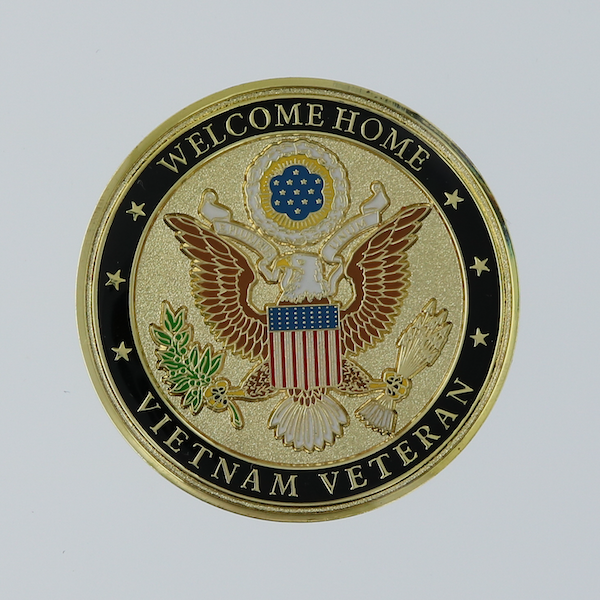Front side of a round gold challenge coin honoring Vietnam veterans. 