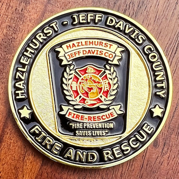 Round polished gold challenge coin belonging to Hazlehurst Fire-Rescue. 