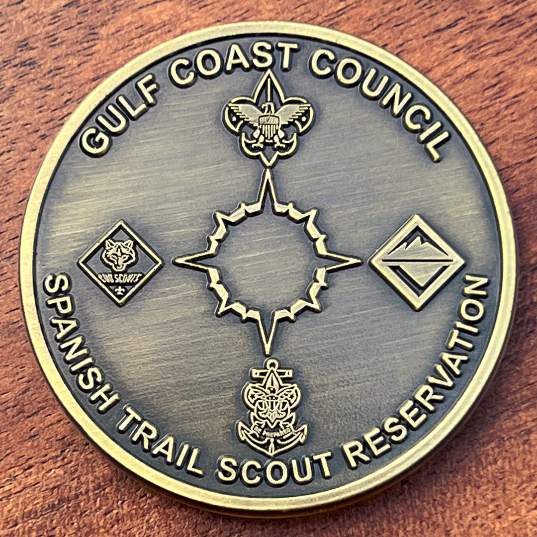 Round antique gold challenge coin belonging to the Boy Scouts Gulf Coast Council. 