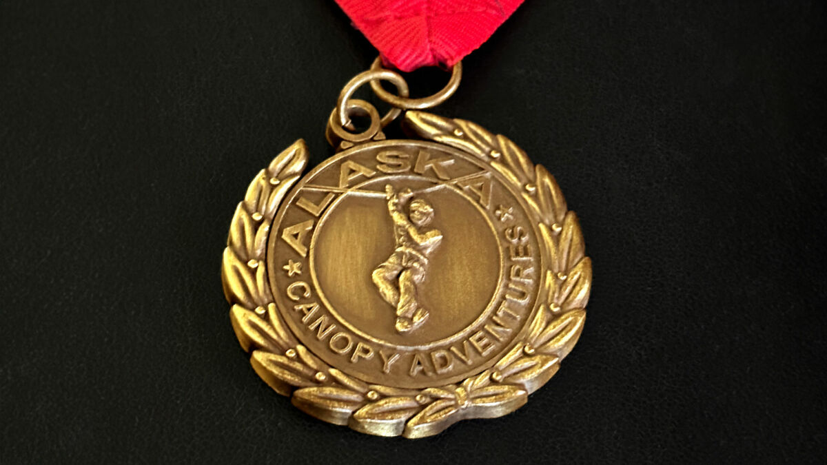 Gold medallion with laurel wreath edge for Alaska Climbing Adventures