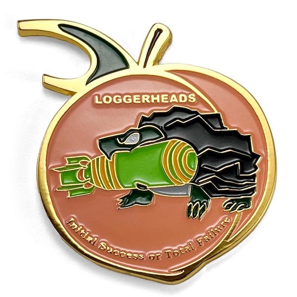 Peach-shaped coin, peach color background, Black loggerhead turtle center, gripping green, orange yelow missile in its mouth. Bottle opener top stem