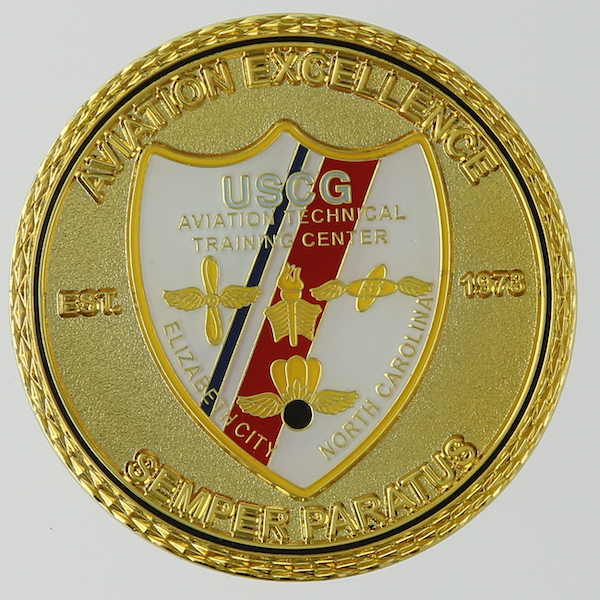 Front side of a round polished gold challenge coin belonging to the United States Coast Guard Aviation Technical Training Center in Elizabeth City, North Carolina. 
