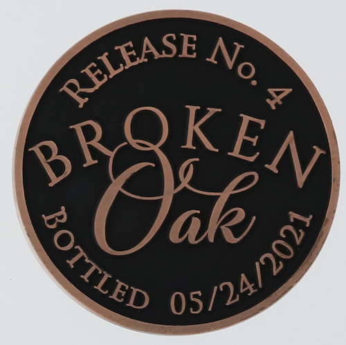Front side of a round challenge coin for Mystic Farm and Distillery to celebrate Broken Oak whiskey. 