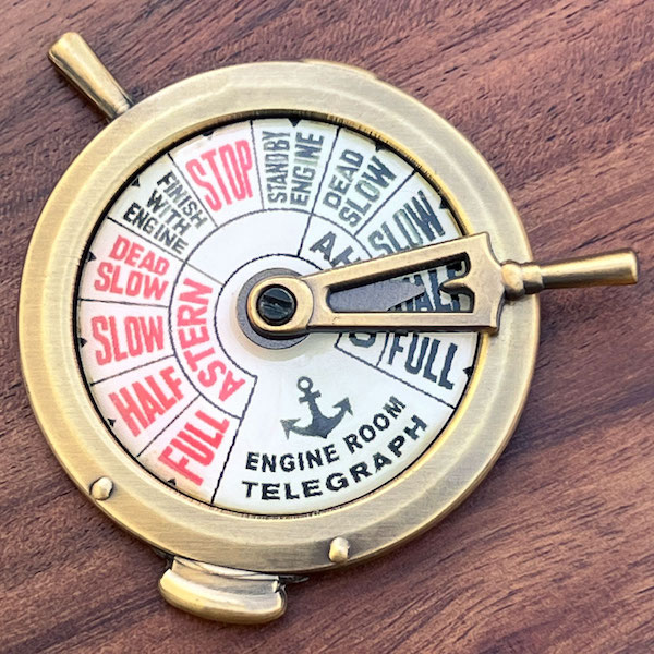Photo of an antiqued gold challenge coin designed to look like a ship's engine telegraph 