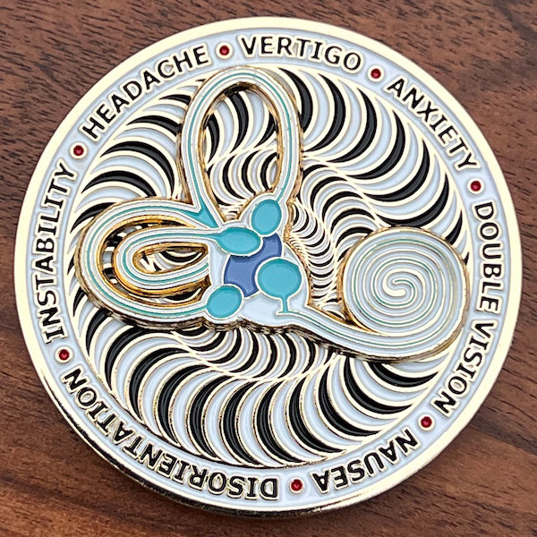 Round gold spinning challenge coin for vertigo awareness. 