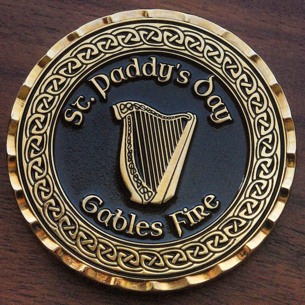Round gold challenge coin representing St. Patrick's Day. 
