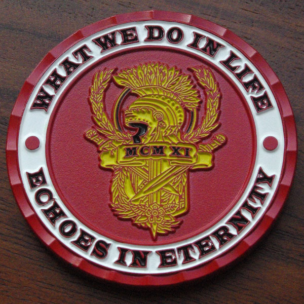 Round red challenge coin with the text "What we do in life echoes in eternity." 