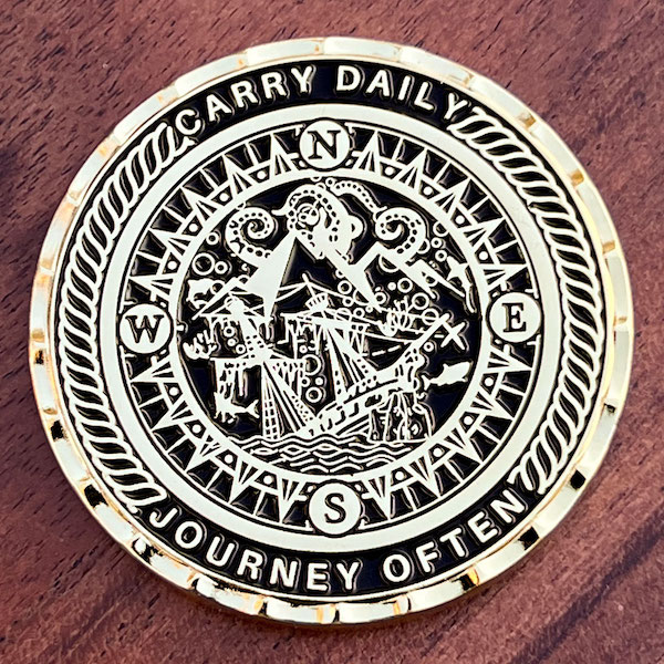 Round polished gold challenge coin with wave cut edge. 