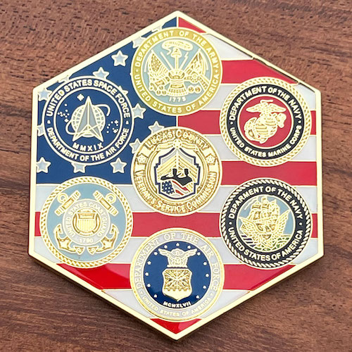 Hexagonal coin featuring the seals of all six U.S. Armed Forces branches on an American flag background