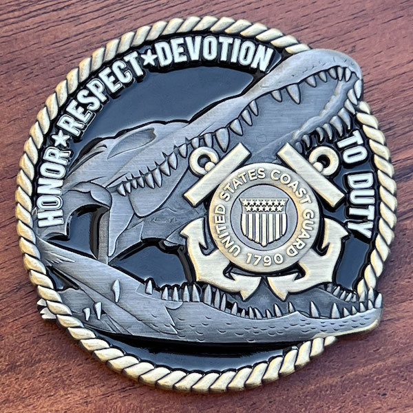 photo of a custom coin featuring a U.S. Coast Guard logo inside the jaws of an alligator skull. Features a rope-cut edge