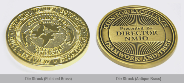 Two round challenge coins. One is die struck polished brass, the other is die struck antique brass